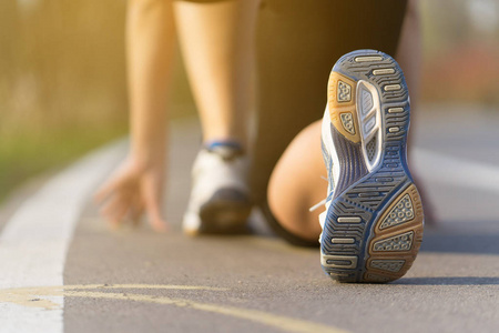 里跑步鞋上绑鞋带鞋带绑在早上的女跑步运动员走路或跑步腿运动鞋子
