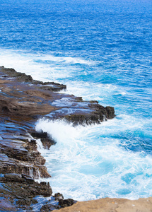 美丽的蓝色海洋水触及对岩石的边缘