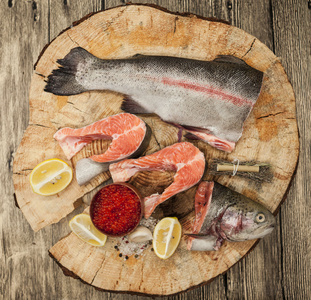 新鲜的挪威虹鳟鱼与柠檬红鱼子酱和洋葱的木制的背景