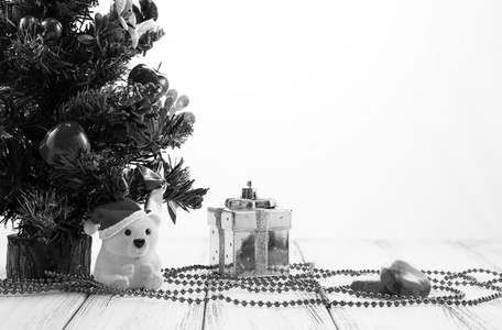 圣诞树 黄金礼品盒 球 玩具熊 糖果和装饰复古老式的白色桌子上白色背景黑色和白色孤立