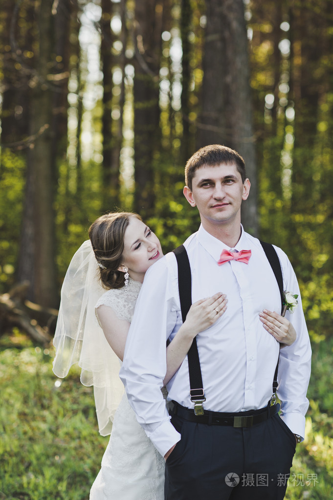 妻子拥抱她丈夫的肩膀在树林里4117