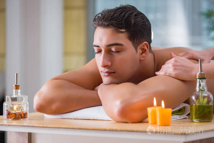 英俊的男人在水疗按摩会议期间