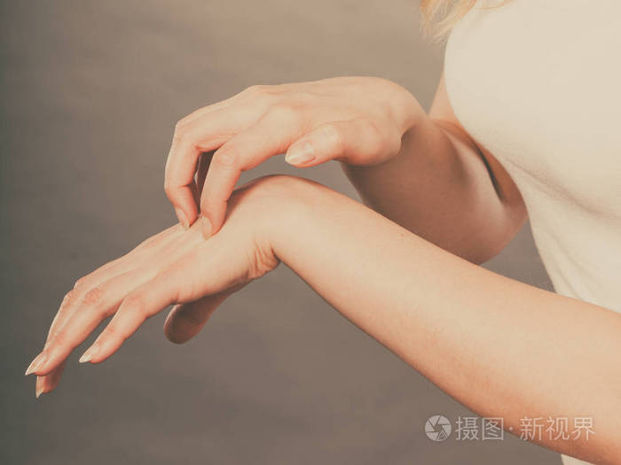 女性搔她痒的手掌与过敏皮疹