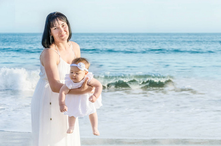 母亲和她的宝贝女儿在沙滩上