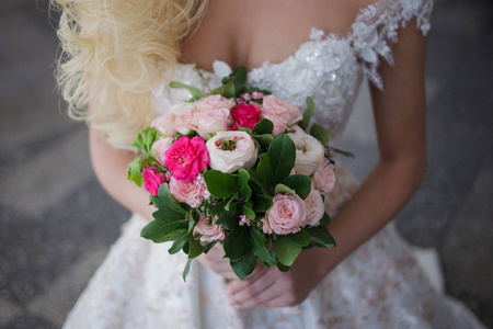 新娘的花束。美丽的女孩在豪华的婚纱，手捧鲜花