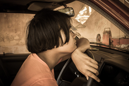 亚洲女孩伤心独自一人坐在那辆旧车，黑色和白色基调