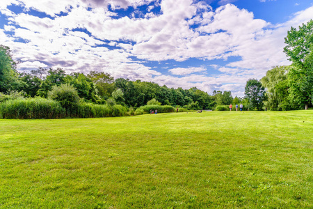 如画的白色悬崖坡,石头和山丘附近美丽的绿色草地在蓝天白云的夏日