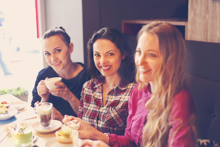 三个年轻女子在一家咖啡馆的一次会议