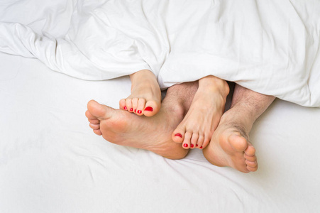 英尺的一对夫妇在床上的毯子