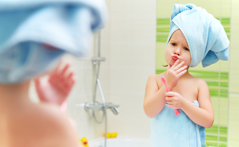 有趣的小女孩清理牙齿用牙刷在浴室