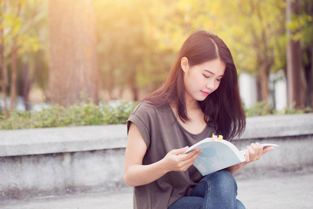 亚洲青少年女性阅读本书快乐，微笑还享受大学教育