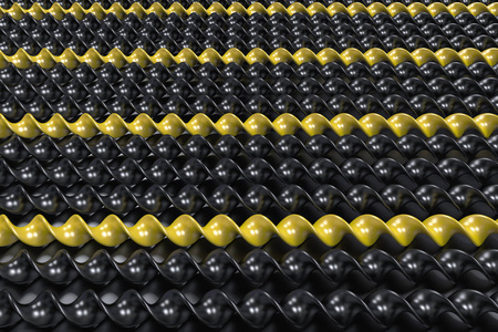 在黑色背景上的黑色和黄色的塑料螺旋棒照片