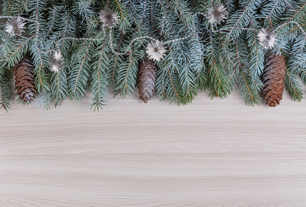 装饰冬季假期满霜与锥和银色珠对木材纹理的云杉分行