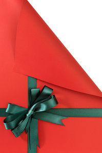 纯红色背景在纸上，左上角的绿色礼物的缎带蝴蝶结