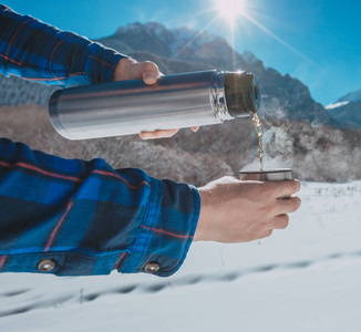 在一座雪山上手持一个热水瓶中的男子