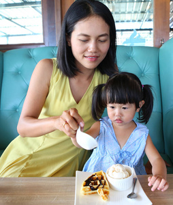 儿童女孩和母亲吃冰淇淋华夫饼