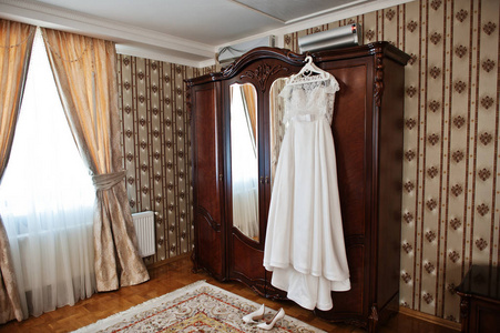 白色的豪华婚纱挂在木柜酒店图片
