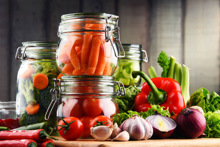 腌制的食物和生蔬菜在砧板上的罐子里