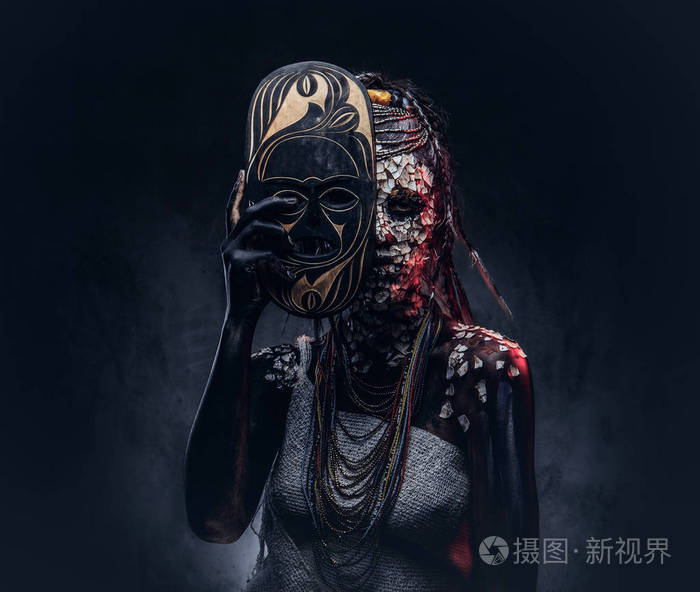 一个可怕的非洲萨满女性的肖像与石化破裂的皮肤和辫子 持有一个传统的面具在黑暗的背景 化妆概念照片 正版商用图片0o0mvy 摄图新视界 一个可怕的非洲萨满女性的肖像与石化破裂的皮肤和辫子 持有一个传统的面具在黑暗的背景 化妆概念照片 正版商用图片0o0mvy 摄图新视界