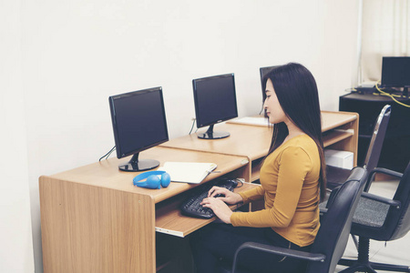 在办公室使用计算机的年轻妇女
