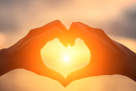 用照片摆心做心的形状,用双手在湖岸上的夫妇.人剪影老式照片照片