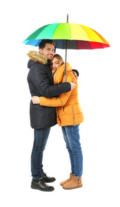 年轻浪漫情侣与彩色雨伞白色背景