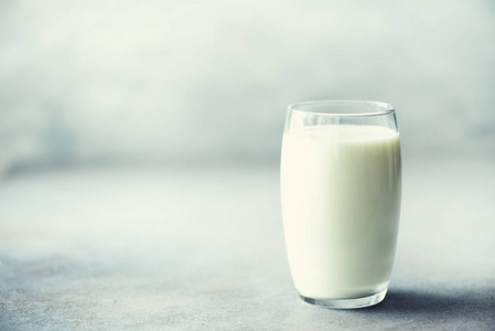 玻璃牛奶在灰色的具体背景汇寄复制空间。健康饮食理念, 素食早餐