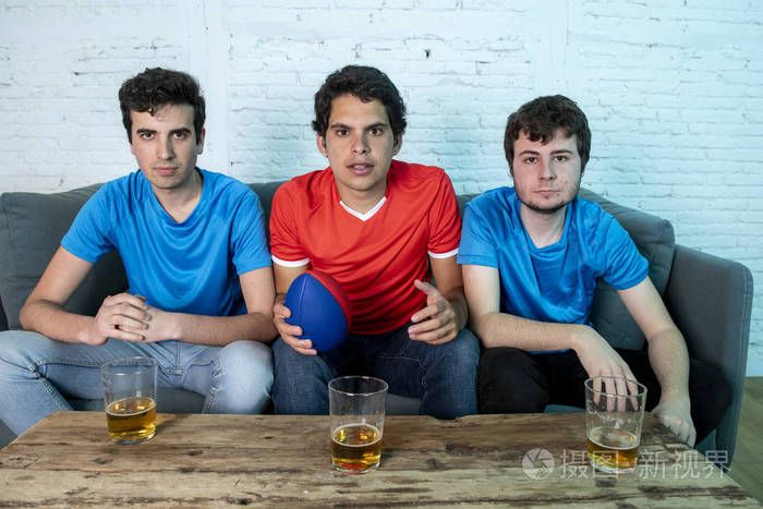 年轻人在观看足球比赛时喝啤酒, 表现出不同的情绪.