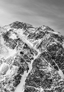 山峰对着天空。白雪覆盖的高山上的黑白相间的山脉