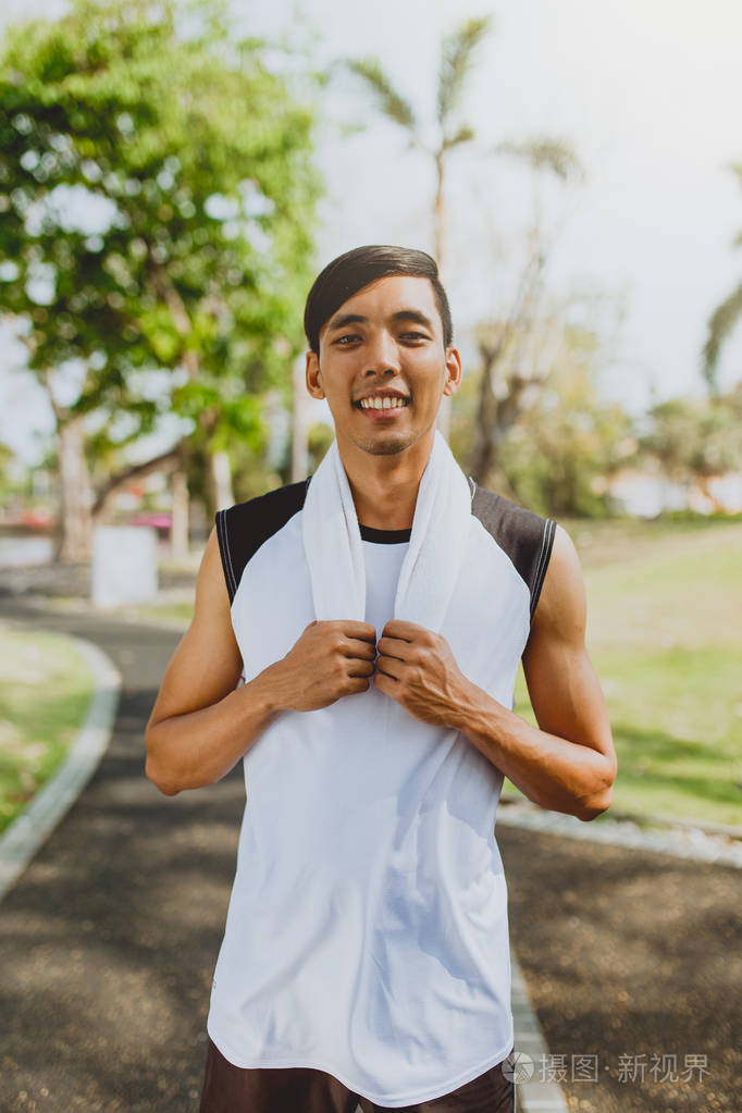 一个男人用白色毛巾锻炼运动后休息锻炼户外公共公园,健康的生活方式