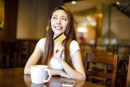 显示信用卡和想法的年轻妇女