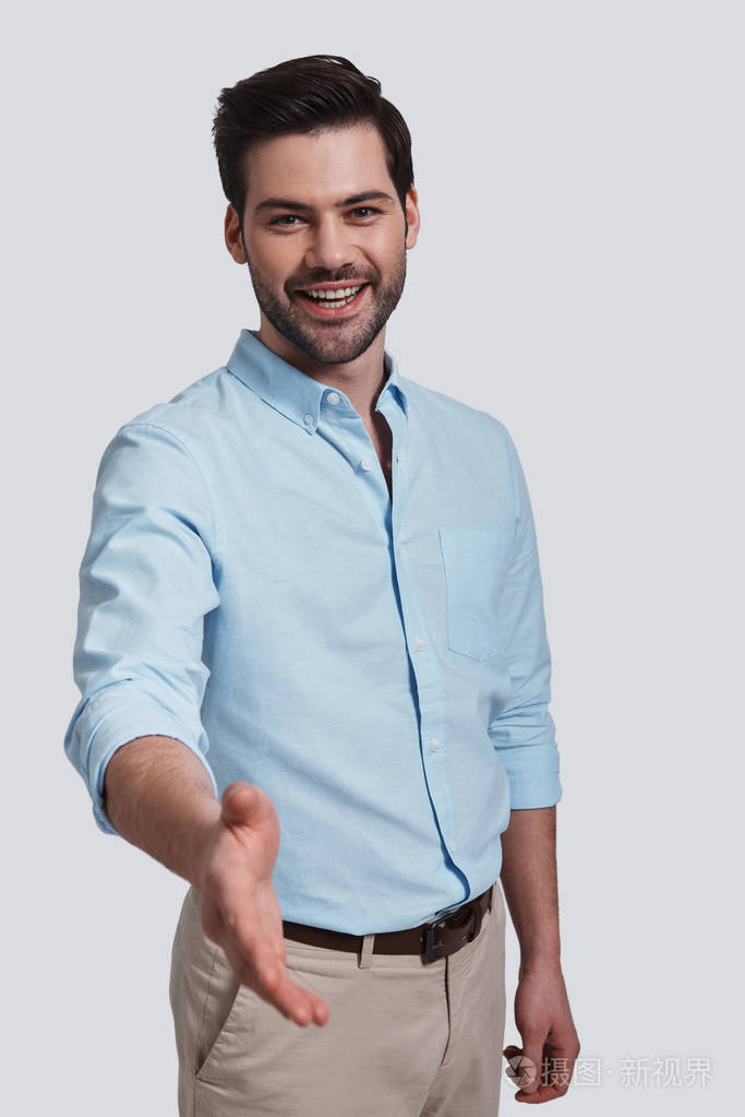 微笑的年轻人手递递握手为问候