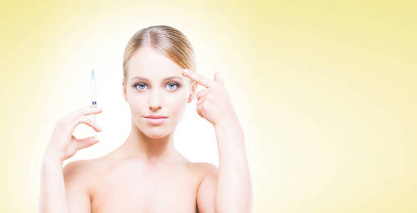 年轻, 美丽和健康的女人有皮肤注射超过黄色背景。整形外科概念