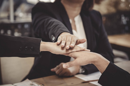 合作伙伴坐在一起握手, 结束会议.