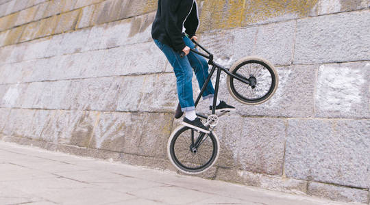 自由式自行车。骑自行车的特技。骑自行车的骑手沿着曲线墙前进
