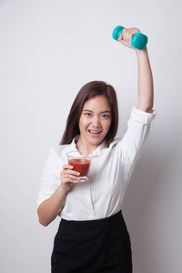 健康的亚洲女性哑铃和番茄汁