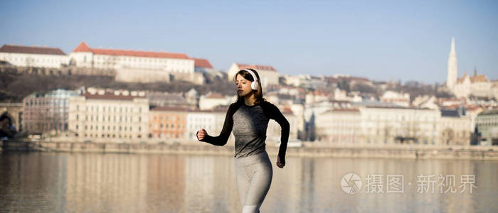 在匈牙利布达佩斯的多瑙河长廊上运行的运动衫女子