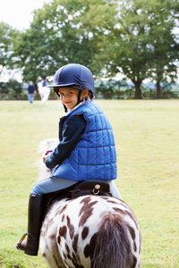 年轻的女孩骑着她的小马