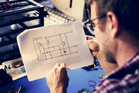 技术人员查看纸张上的电阻电路