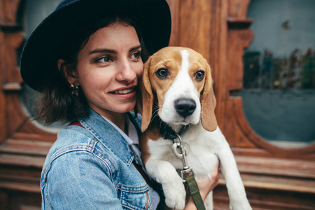 站在老木门旁边的女人手里拿着小猎犬