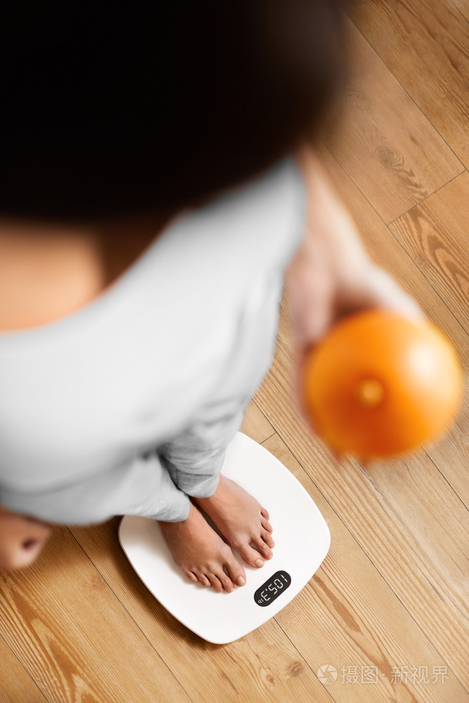 女人在秤上.体重减轻.饮食