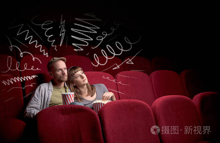 可爱的情侣在电影院看电影