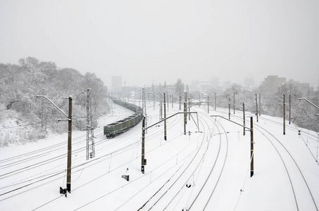 一辆长途货车正沿着铁轨行驶。降雪后冬季的铁路景观