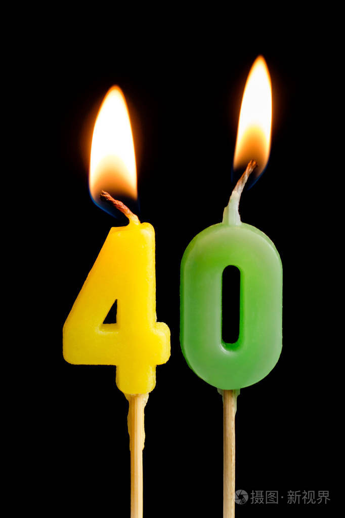 燃烧蜡烛的形式四十数字数字日期的蛋糕被隔离在黑色背景庆祝生日周年