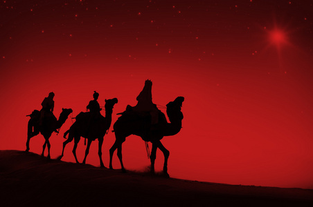 男子骑着骆驼穿越沙漠图片