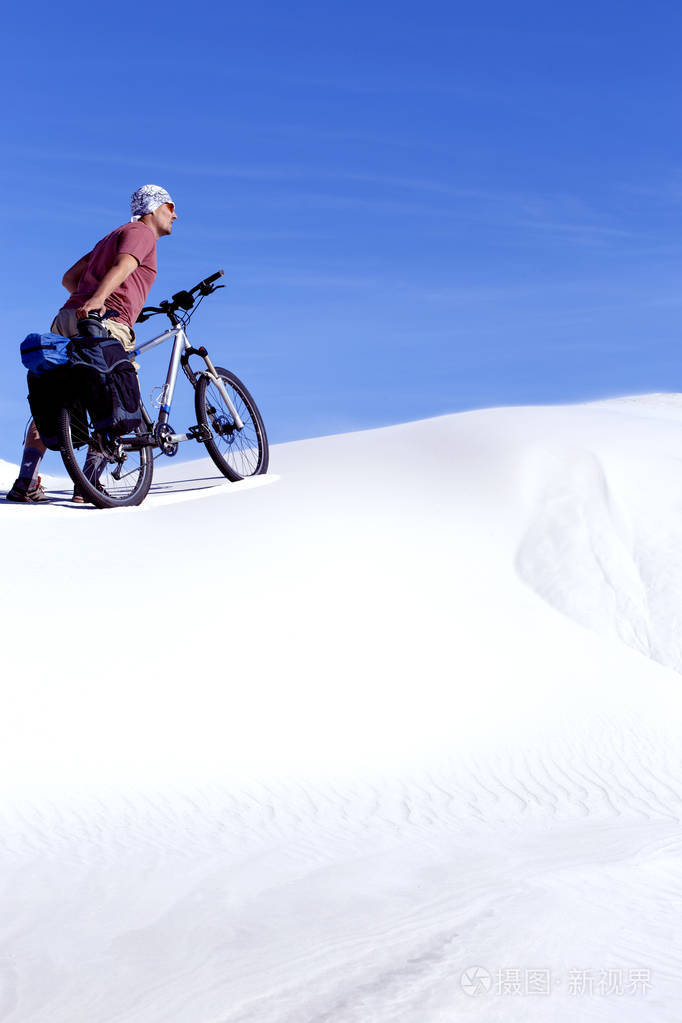 骑着自行车在沙漠中旅行的人