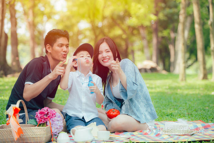 亚洲青少年家庭快乐假日野餐片刻在公园里