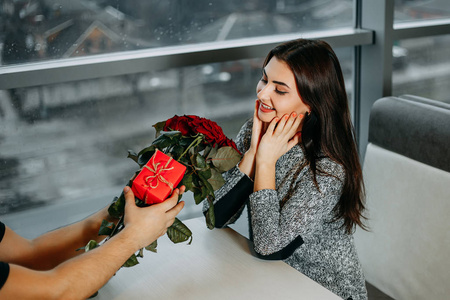 年轻迷人的快乐的女人得到了美丽的花束红玫瑰