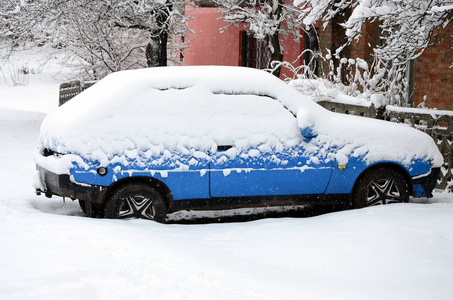 一辆车的照片覆盖在厚层的积雪。大雪的后果