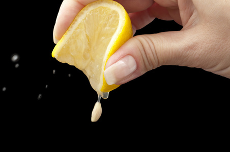 新鲜柠檬汁到玻璃在表挤柠檬汁在厨房里的女人把柠檬挤汁手上的手挤柠